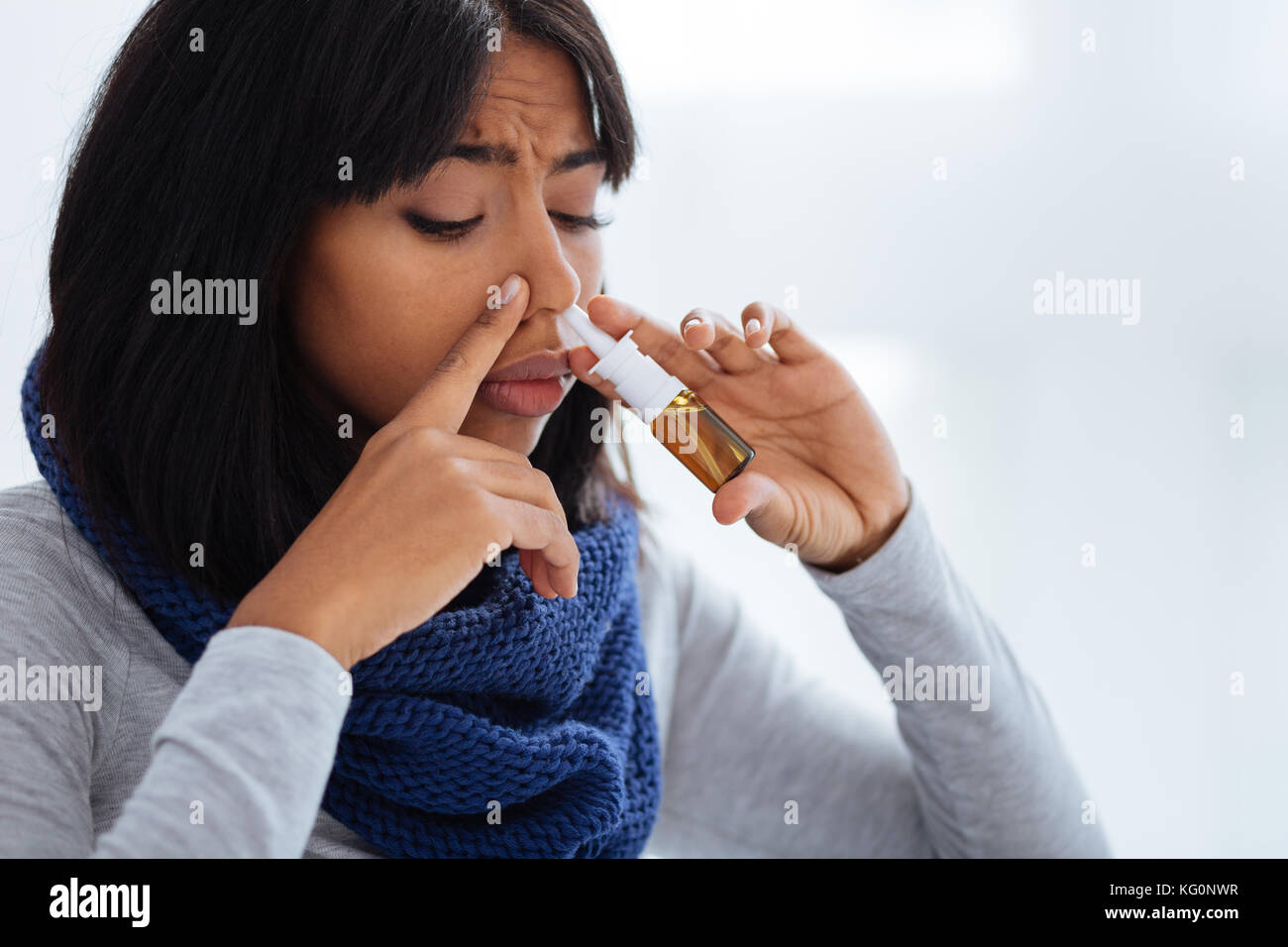 Femme malheureuse concentré en utilisant des gouttes Banque D'Images