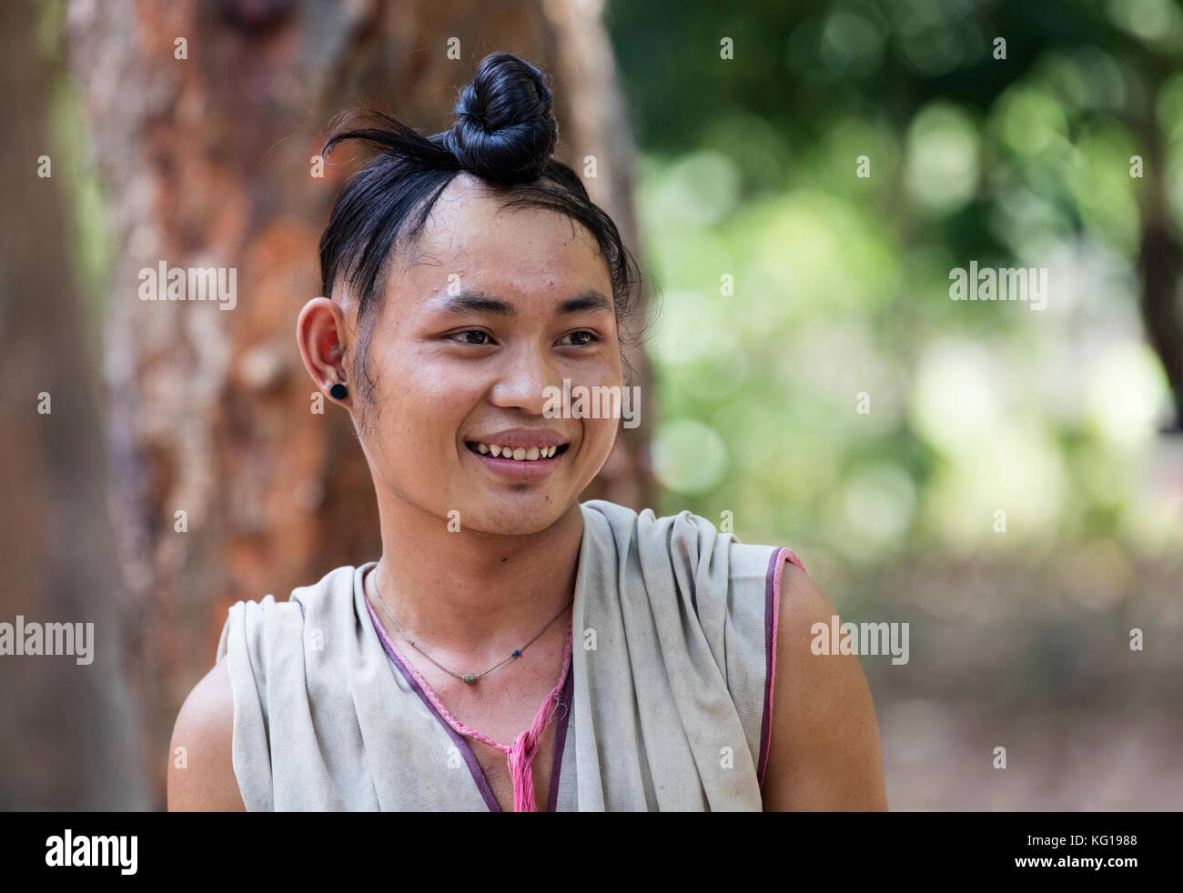 Close up portrait of young man bamar aux cheveux longs attachés en un nœud dans l'État kayin village près de la ville de hpa-an, kayin state / l'État karen, myanmar / burm Banque D'Images