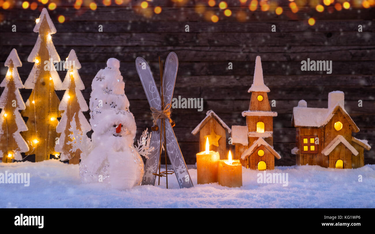 Noël arrière-plan éclairé avec village en bois, bonhomme de neige et l'arbre de Noël en bois sombre. arrière-plan avec l'espace libre pour le texte. Célébration de chri Banque D'Images