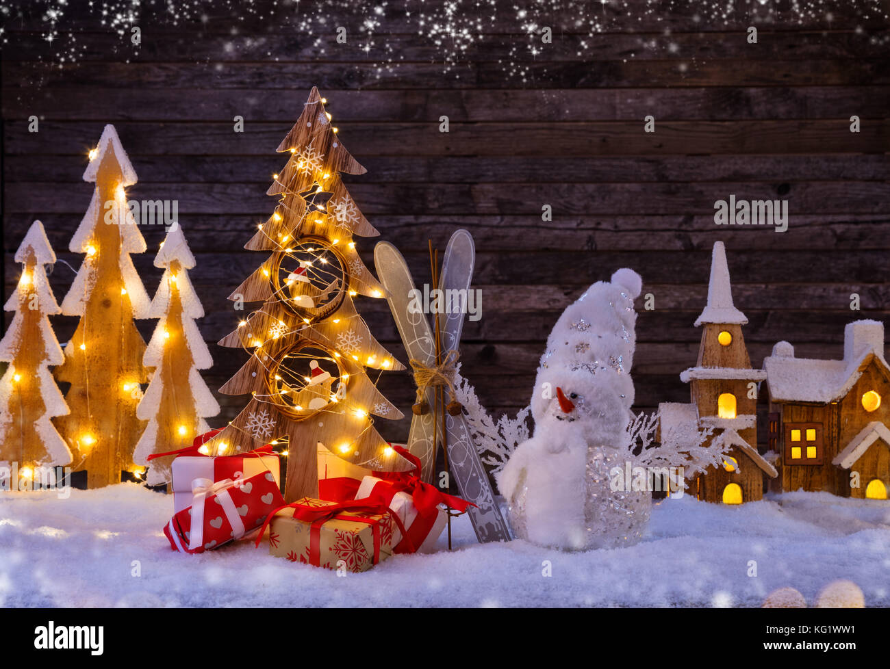 Noël arrière-plan éclairé avec village en bois, bonhomme de neige et l'arbre de Noël en bois sombre. arrière-plan avec l'espace libre pour le texte. Célébration de chri Banque D'Images