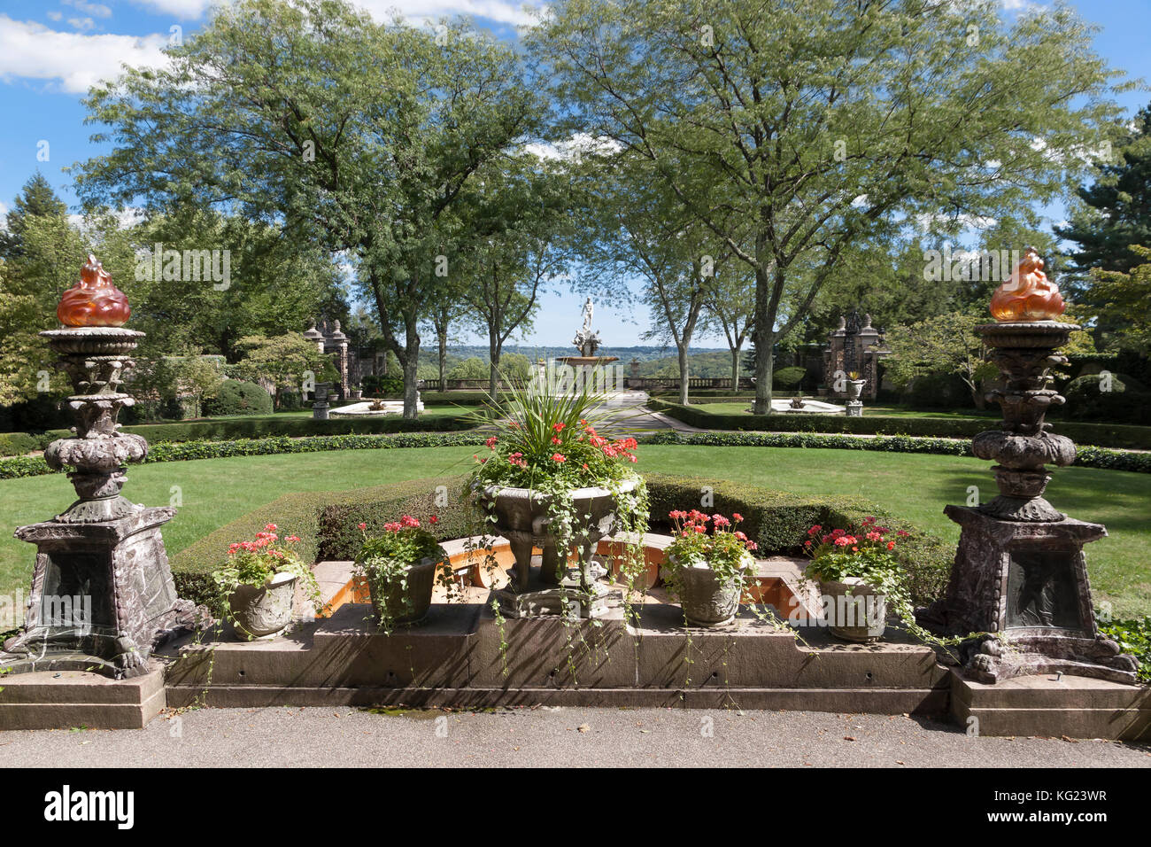 Avis de Kykuit estate de l'avant de la chambre : 2 torches géantes avec globes en verre Tiffany donnant sur arbres du criquet du miel & statue de Oceanus. Banque D'Images