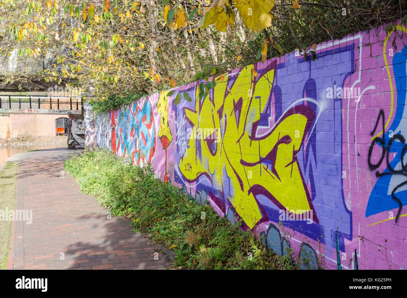 Graffitis colorés peints sur des murs en brique à côté du chemin de halage du canal en direction de Digbeth Digbeth, Birmingham, Royaume-Uni Banque D'Images