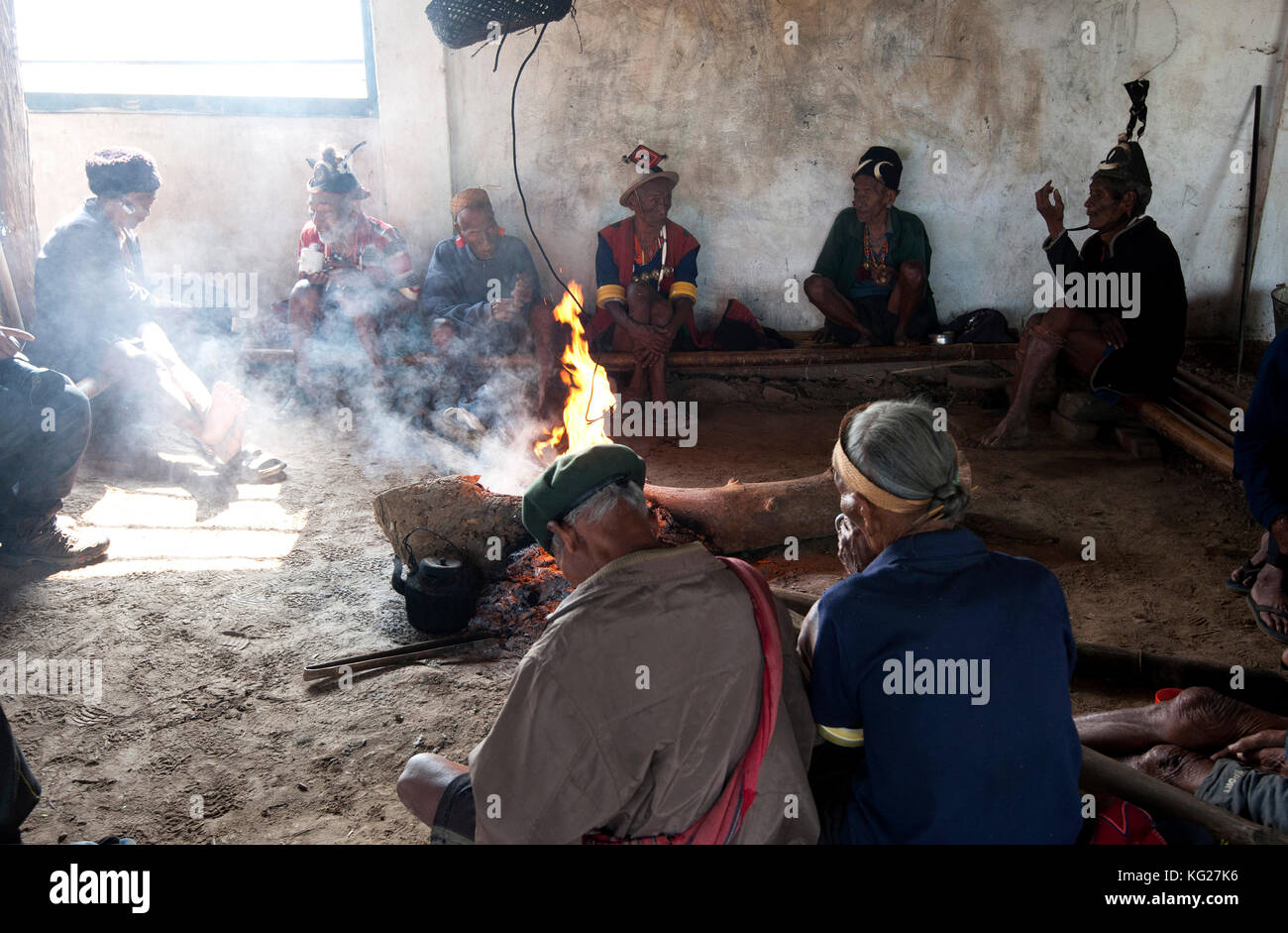 Les hommes assis bavardant naga autour du feu central dans leur village murung (salle des fêtes), hongphui village, Nagaland, l'Inde, l'Asie Banque D'Images