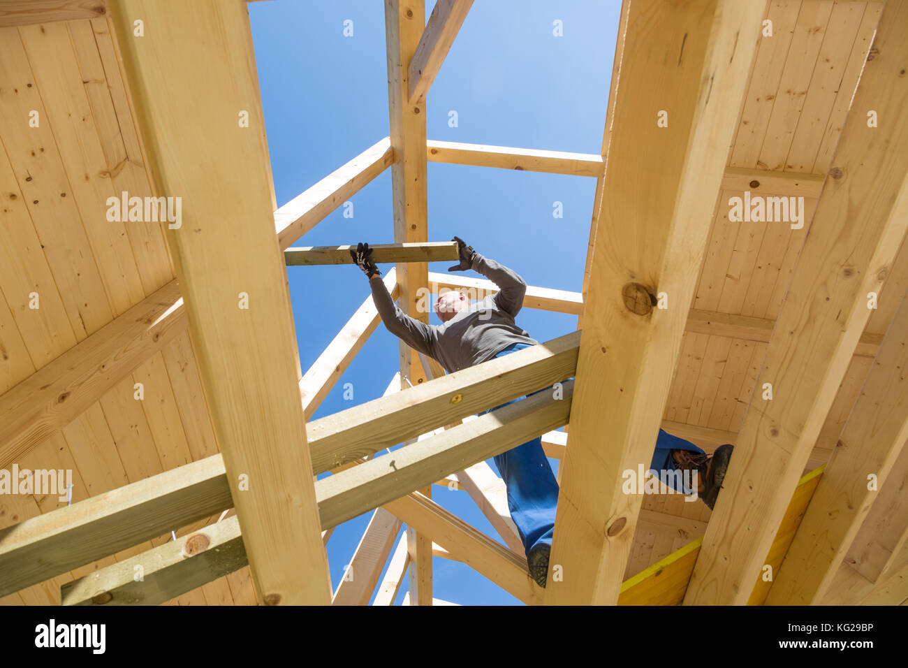 Builder au travail avec un toit en bois de construction. Banque D'Images
