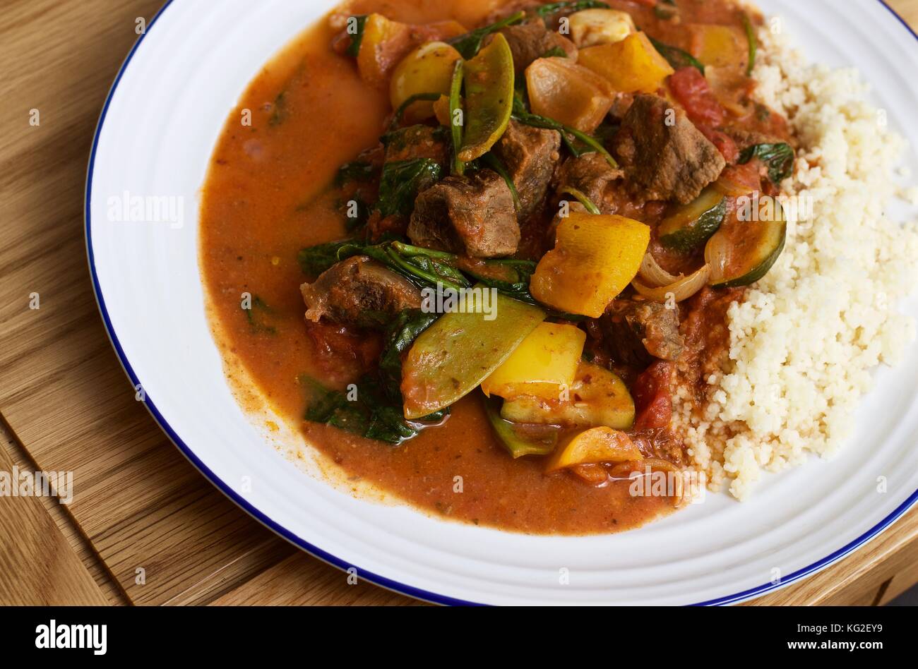 Curry de bœuf saag Goht fait maison avec riz blanc sur une assiette blanche sur une table en chêne Banque D'Images