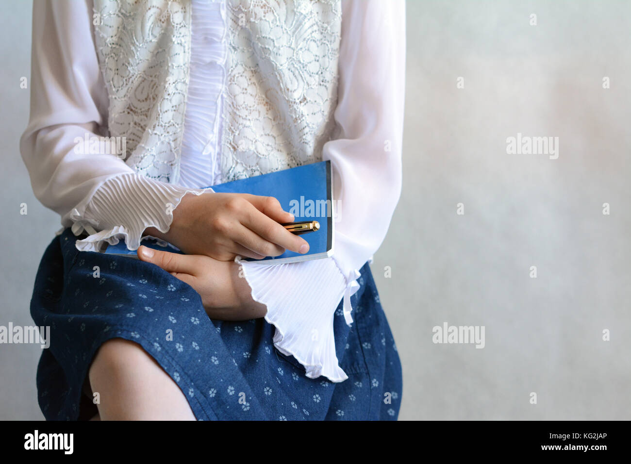 Première journée à l'école - une fille portant un chemisier blanc et une jupe bleu foncé Banque D'Images