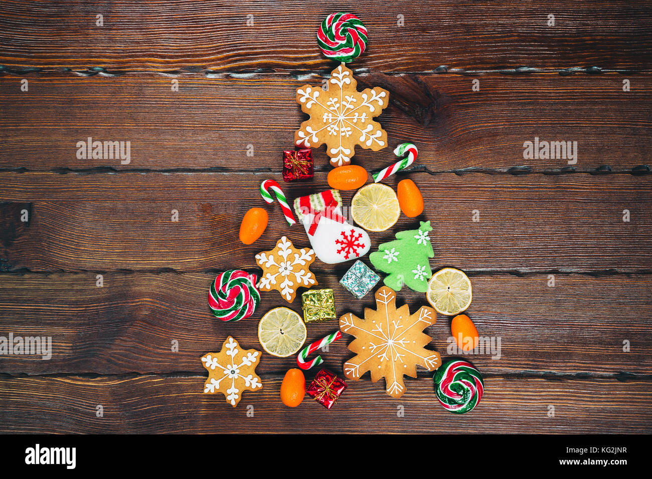 Arbre de Noël avec des bonbons de gingerbreads, bonbons et des décorations traditionnelles en bois sur un vieux fond brun. joyeux noël concept. espace libre Banque D'Images Arbre de Noël avec des bonbons de gingerbreads, bonbons et des décorations traditionnelles en bois sur un vieux fond brun. joyeux noël concept. espace libre Banque D'Images