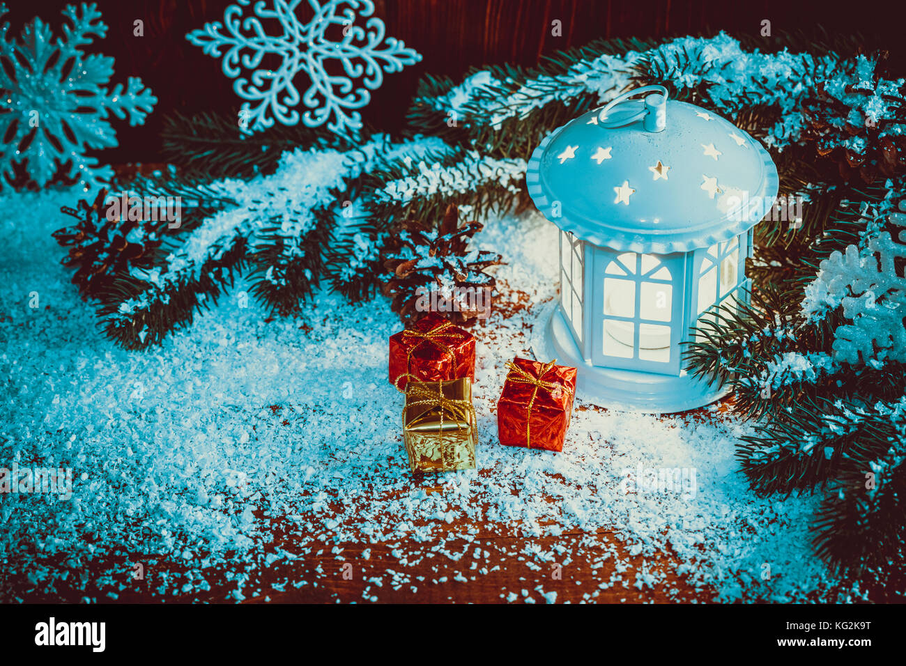 Noël lanterne avec éclairée par des bougies, des branches d'arbre de Noël, de cadeaux, de cônes, de flocons de neige et sur fond de bois vintage espace libre. Banque D'Images Noël lanterne avec éclairée par des bougies, des branches d'arbre de Noël, de cadeaux, de cônes, de flocons de neige et sur fond de bois vintage espace libre. Banque D'Images
