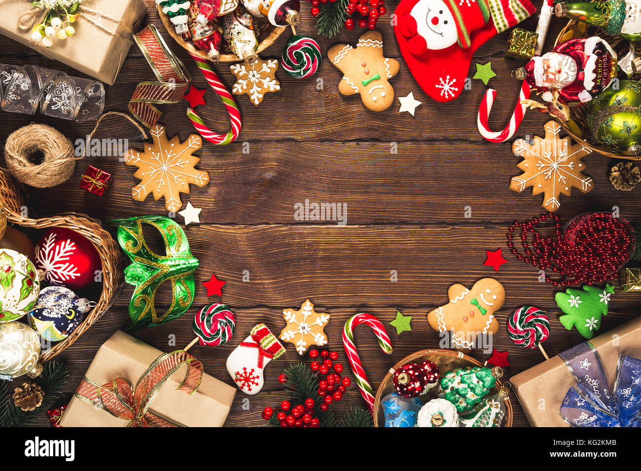 Fond de noël avec cadeaux, jouets, des branches d'arbre, le nouvel an du décor, bonbons et biscuits au gingembre sur le vieux fond de bois. cadre avec l'espace libre Banque D'Images Fond de noël avec cadeaux, jouets, des branches d'arbre, le nouvel an du décor, bonbons et biscuits au gingembre sur le vieux fond de bois. cadre avec l'espace libre Banque D'Images