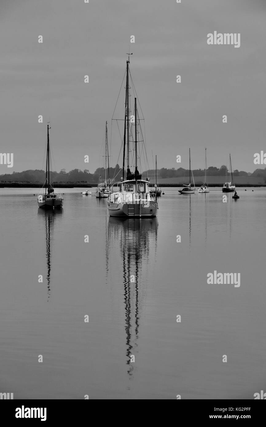 Portrait noir et blanc du bateau à voile « Odin » et de son reflet, amarré dans la rivière Deben à Waldringfield. Banque D'Images