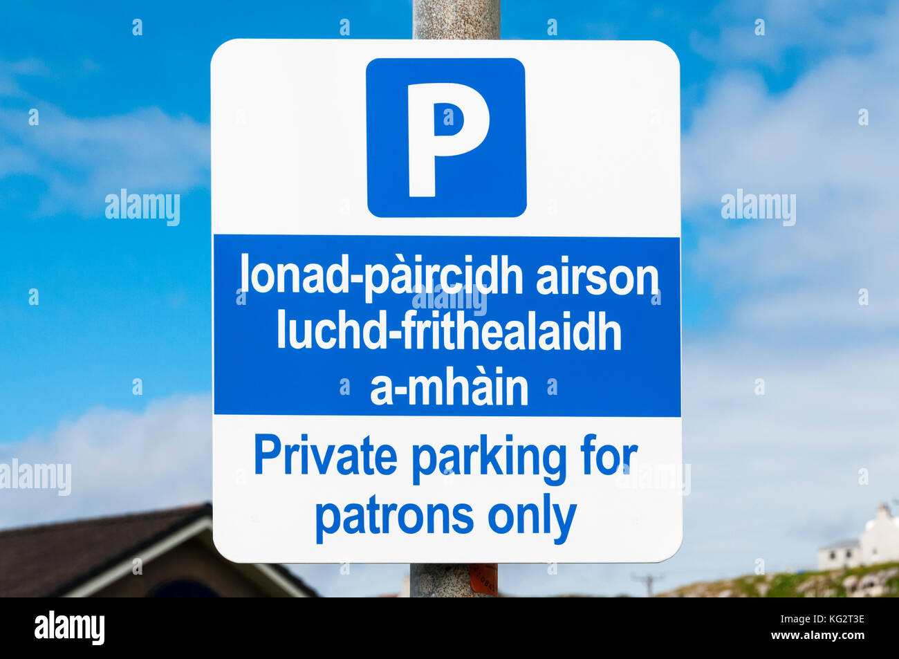 Lecture de panneaux parking privé pour les clients uniquement, en anglais et en gaélique. Banque D'Images
