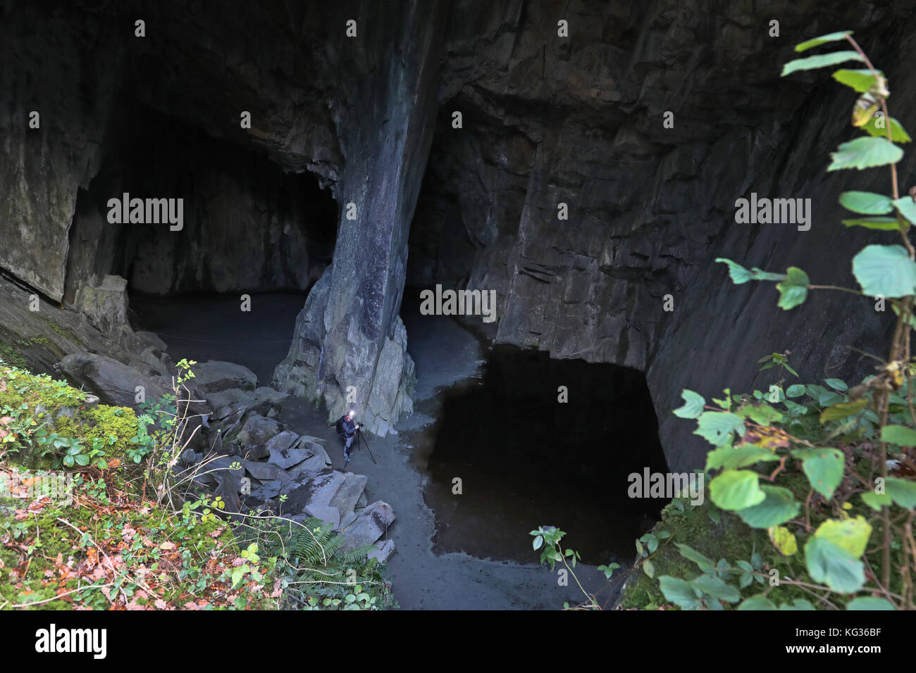 Un photographe dans la grotte de la cathédrale, une partie des carrières de la cathédrale à Langdale, dans le Lake District, Cumbria, appartenant et géré par le National Trust, le petit réseau de carrières interreliées sont plus connus pour sa chambre principale, la cathédrale, qui mesure quarante pieds de hauteur et est éclairé par deux fenêtres de la carrière principale. Banque D'Images