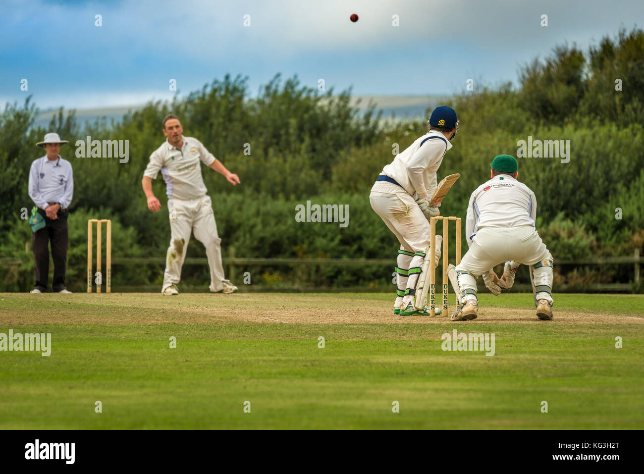 Un batteur se prépare à jouer une balle au cours d'un match de championnat dimanche entre deux équipes de cricket locaux. Banque D'Images