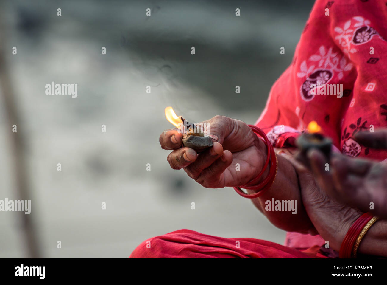 Femme hindoue main tenant à la main une lampe d'argile avec feu sacré pour ganga puja à Varanasi en Inde. Banque D'Images