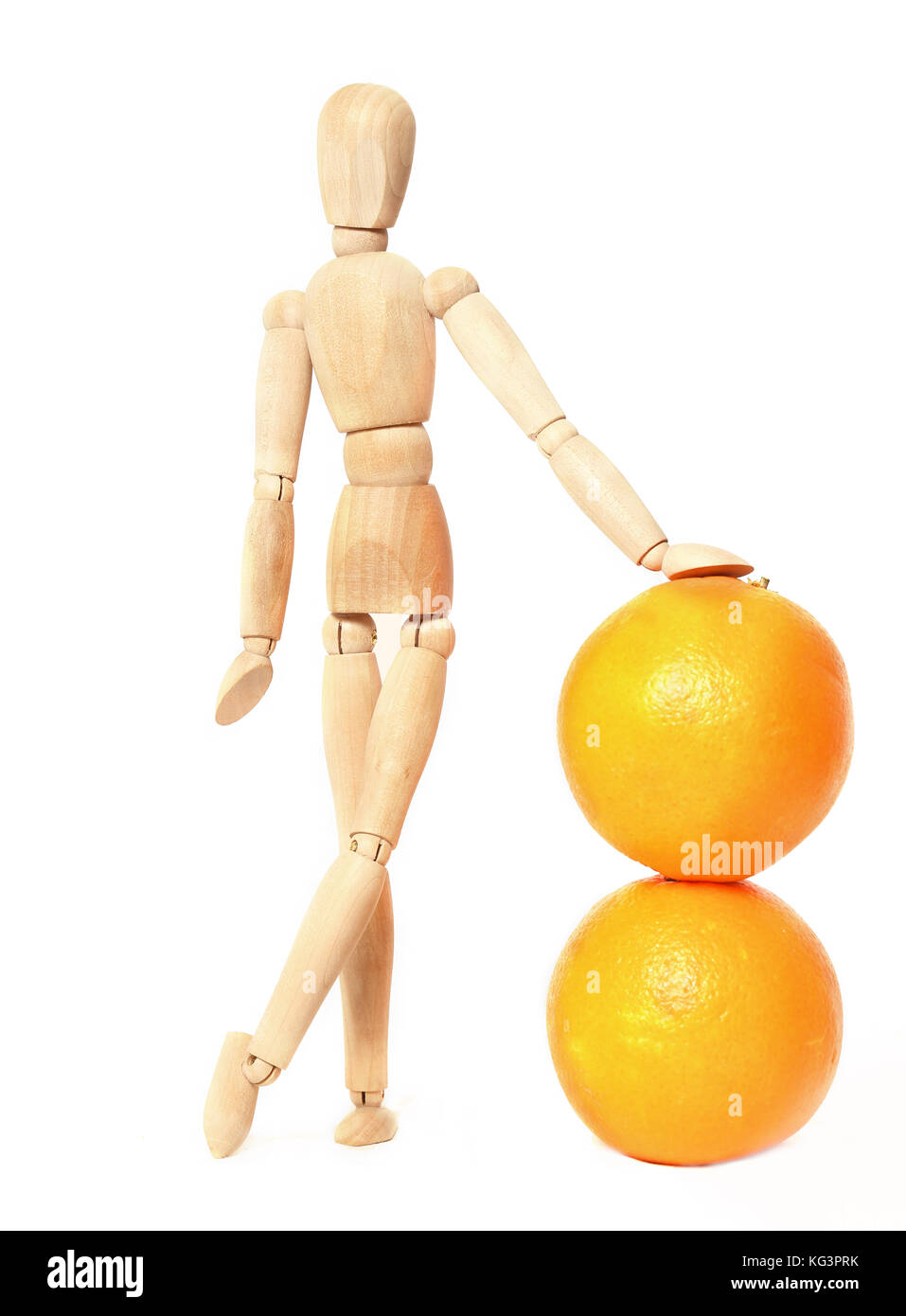 Poupée en bois et des oranges sur fond blanc. le simulacre en bois s'appuie une main sur deux oranges. Il est isolé sur fond blanc Banque D'Images