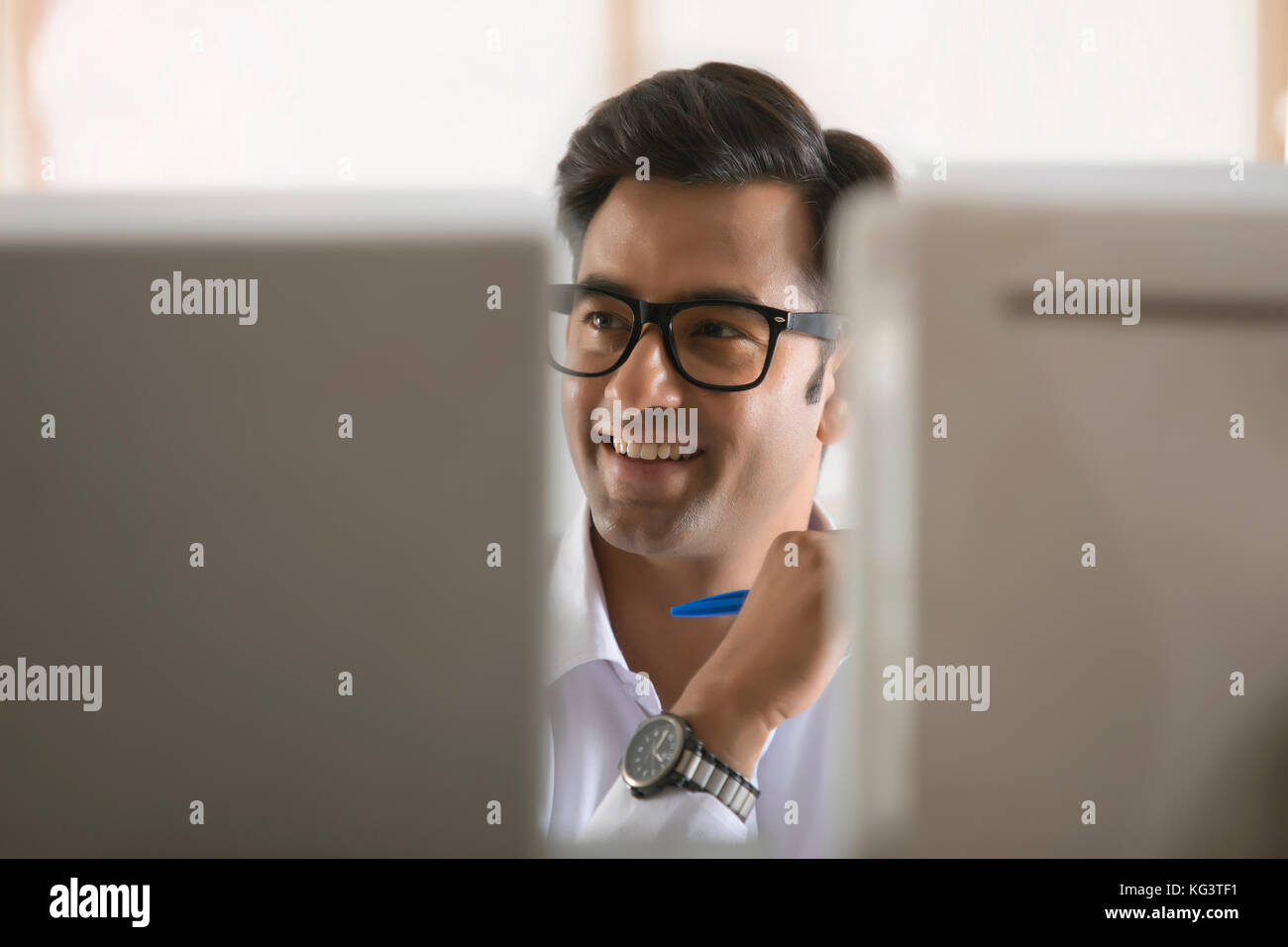 Portrait of businessman working on desktop pc in office Banque D'Images
