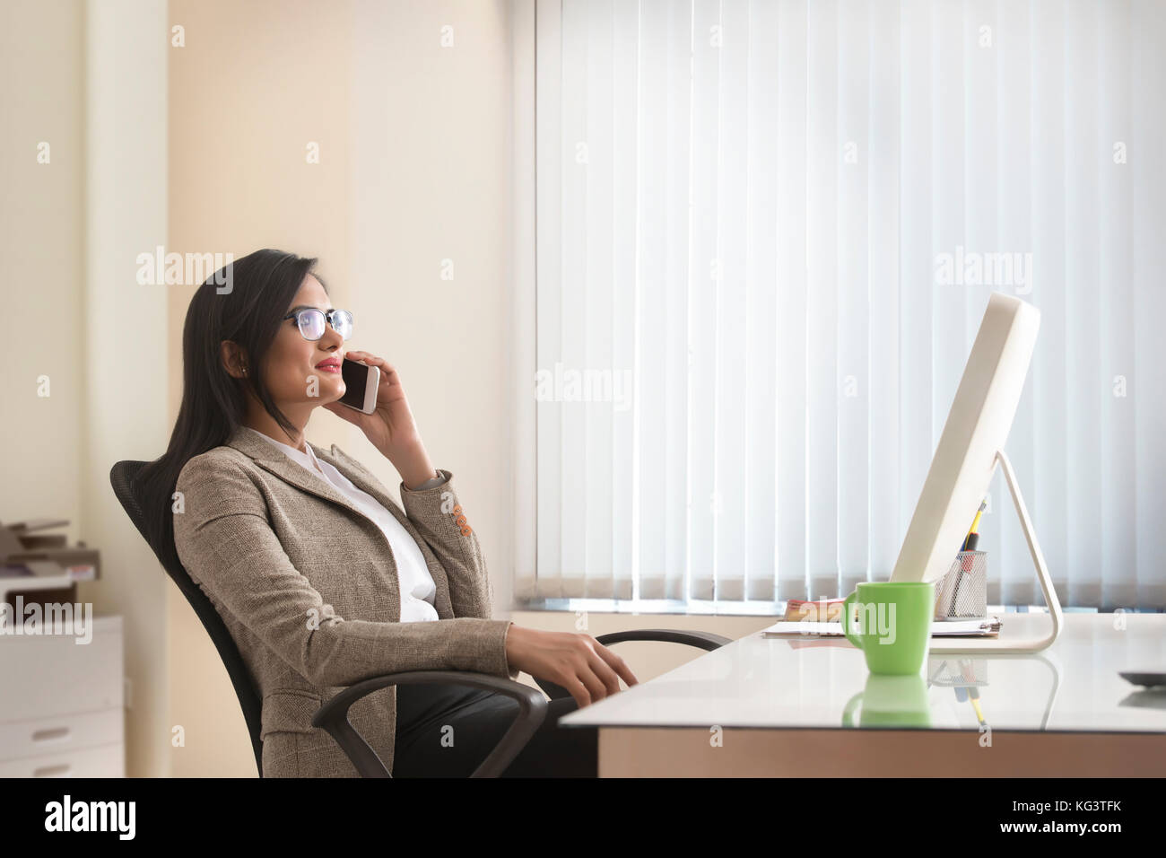 Businesswoman talking on mobile phone in office Banque D'Images