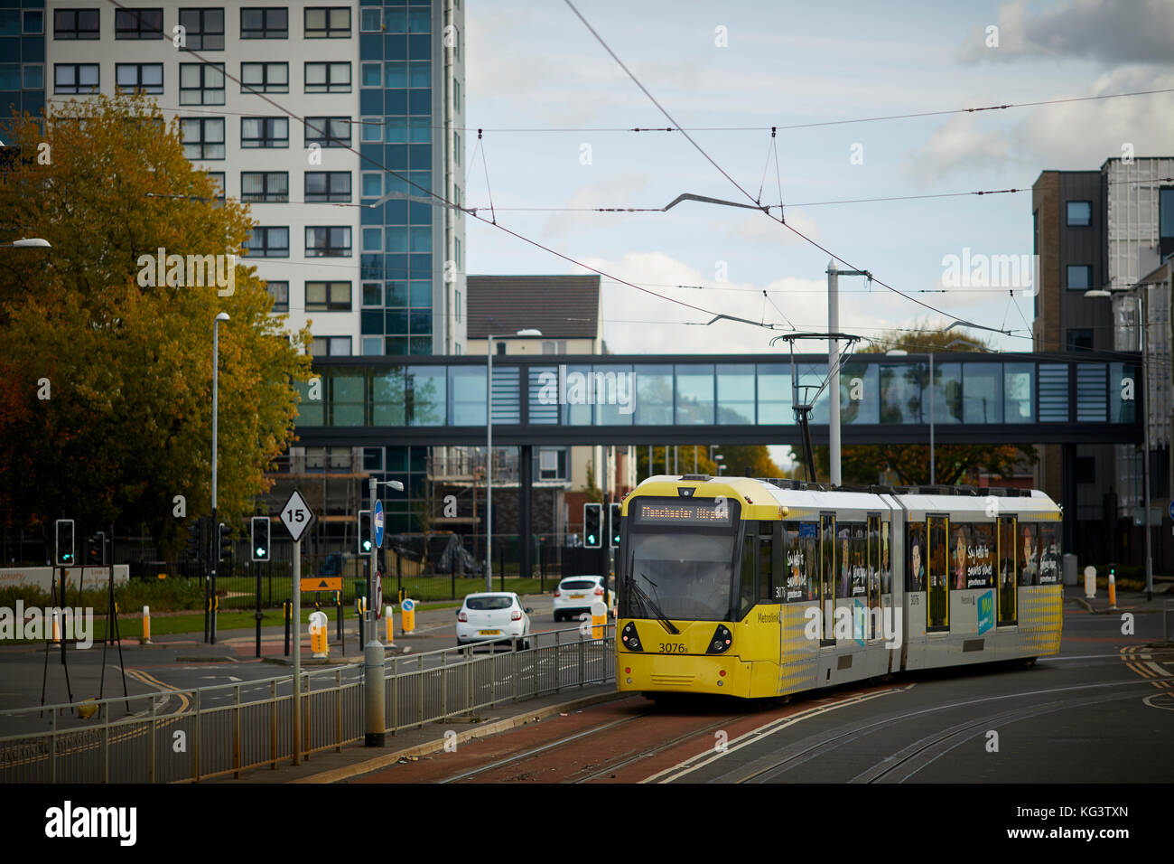 Manchester Metrolink jaune un tramway à Hollyhedge Road, Benchill, Wythenshawe. Village de retraite 135 logements pour les plus de 55 ans Banque D'Images