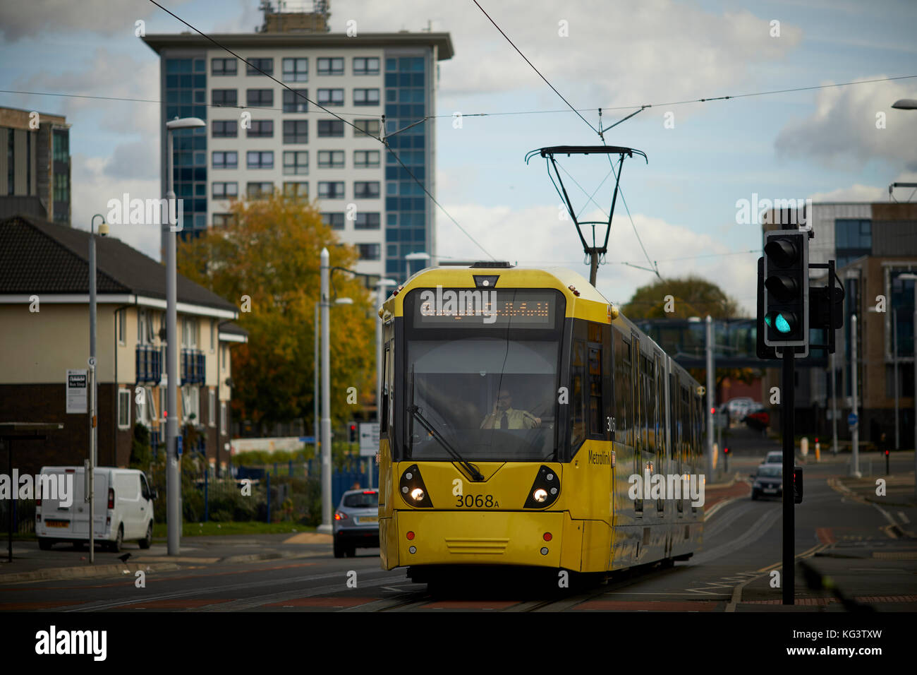 Manchester Metrolink jaune un tramway à Hollyhedge Road, Benchill, Wythenshawe. Village de retraite 135 logements pour les plus de 55 ans Banque D'Images