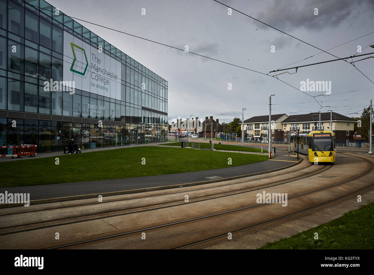 Manchester Metrolink jaune un tramway à Hollyhedge Road, Benchill, Wythenshawe. passer l'édifice moderne a daigné Manchester College Banque D'Images