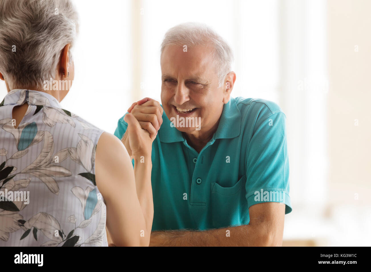 Senior couple Arm wrestling at table Banque D'Images
