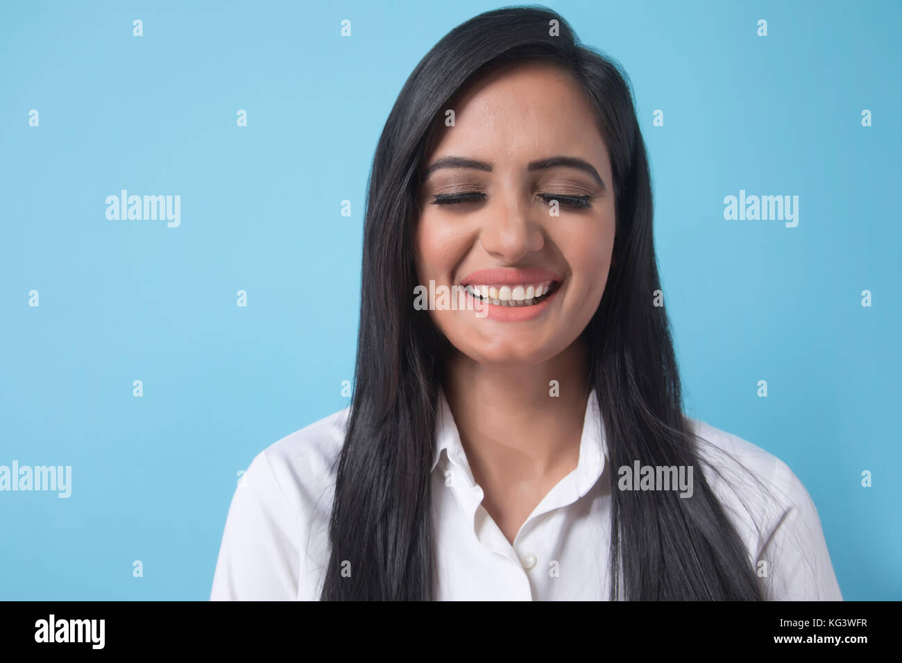 Portrait of smiling young businesswoman sur fond bleu Banque D'Images