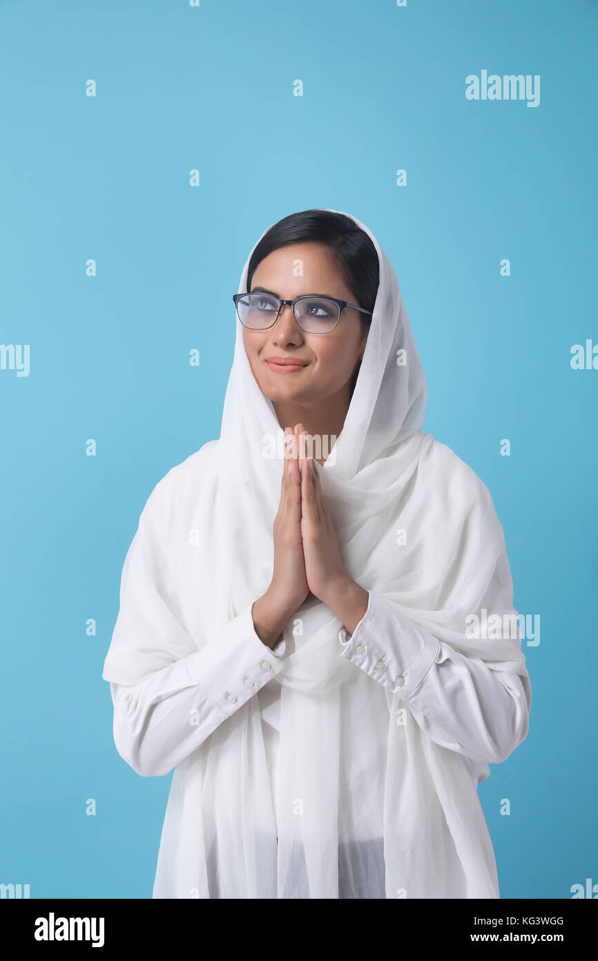 Woman wearing white dupatta debout dans la position de prière Banque D'Images