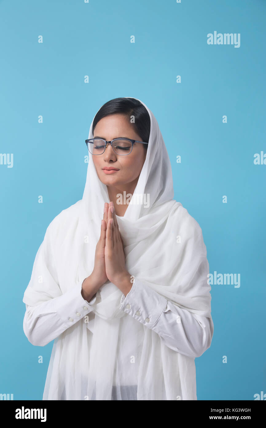 Woman wearing white dupatta debout dans la position de prière Banque D'Images