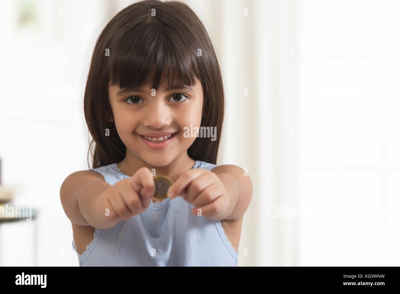 Smiling girl holding coin Banque D'Images