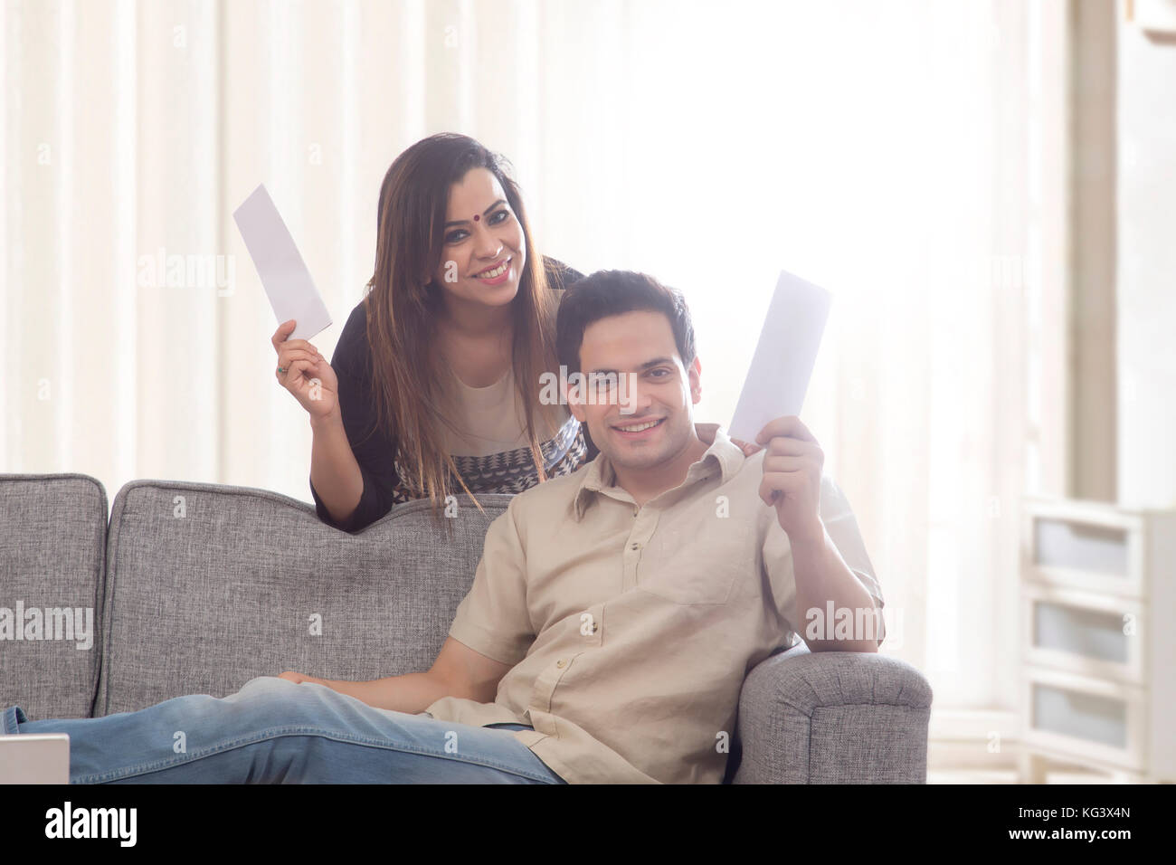 Cheering Couple avec papier finances accueil Banque D'Images
