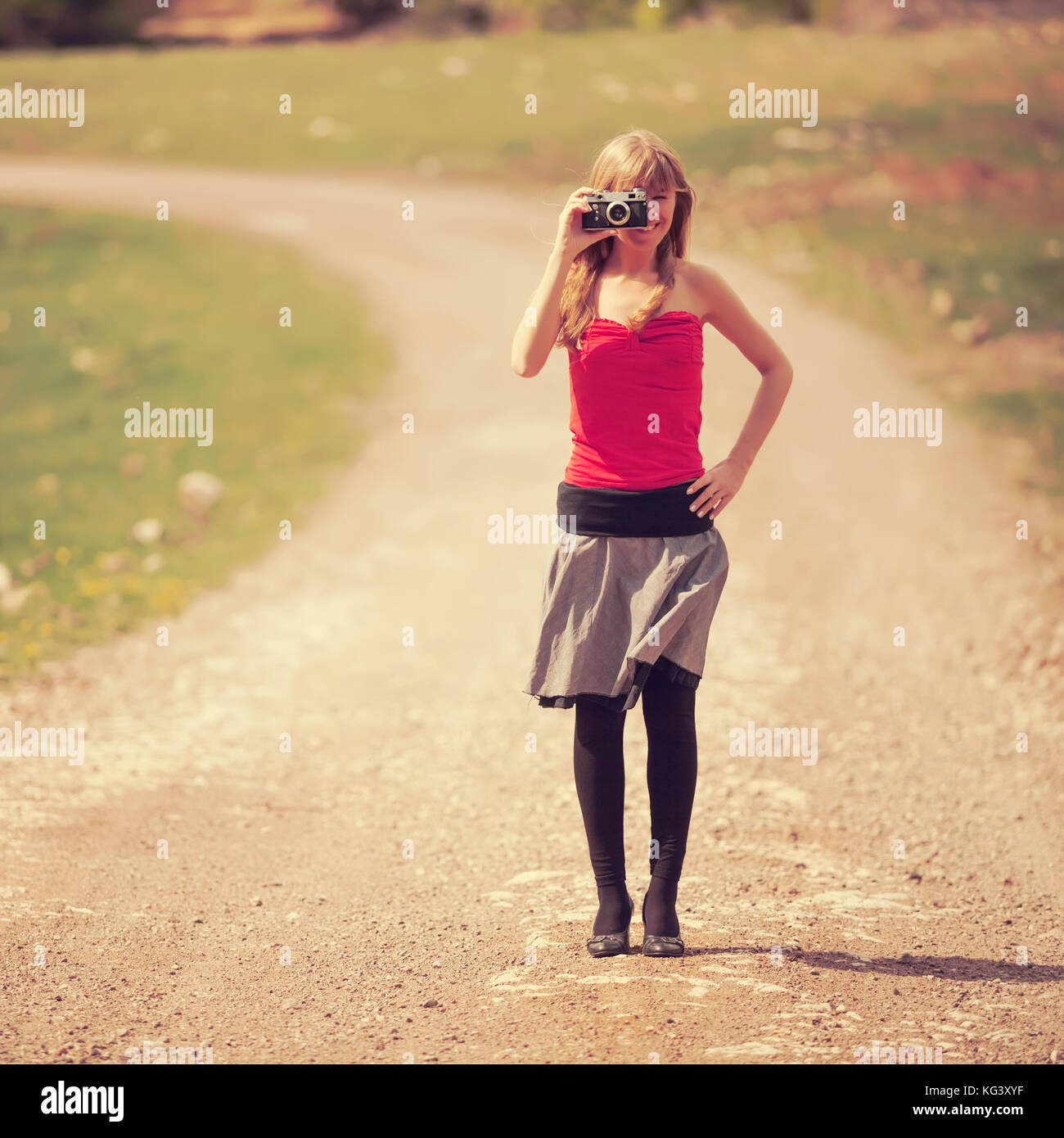 Woman taking photo on country road, tons intentionnellement. Banque D'Images
