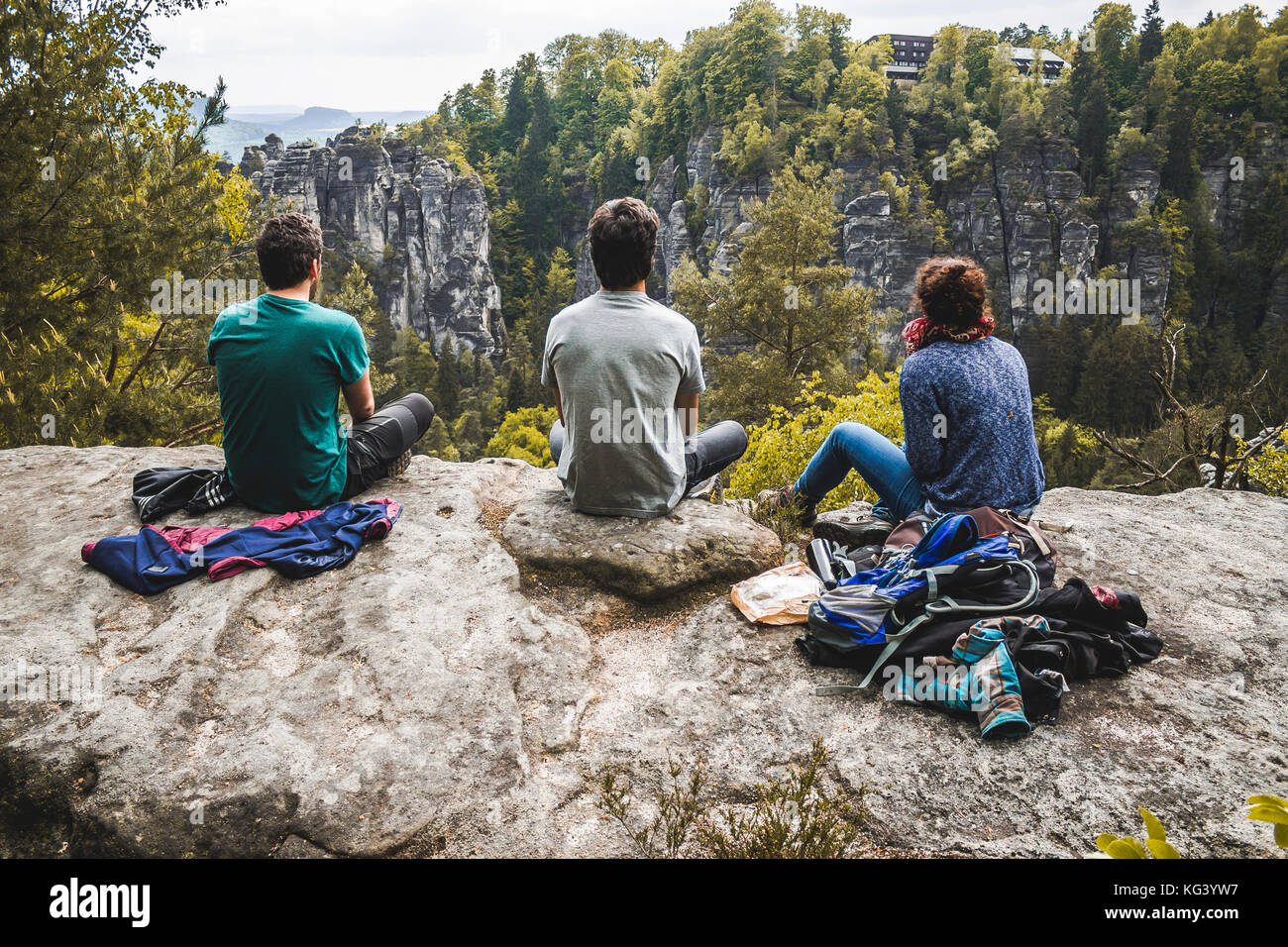 Trois jeunes qui s'assoyent en regardant le paysage - Parc national de la Suisse saxonne Banque D'Images