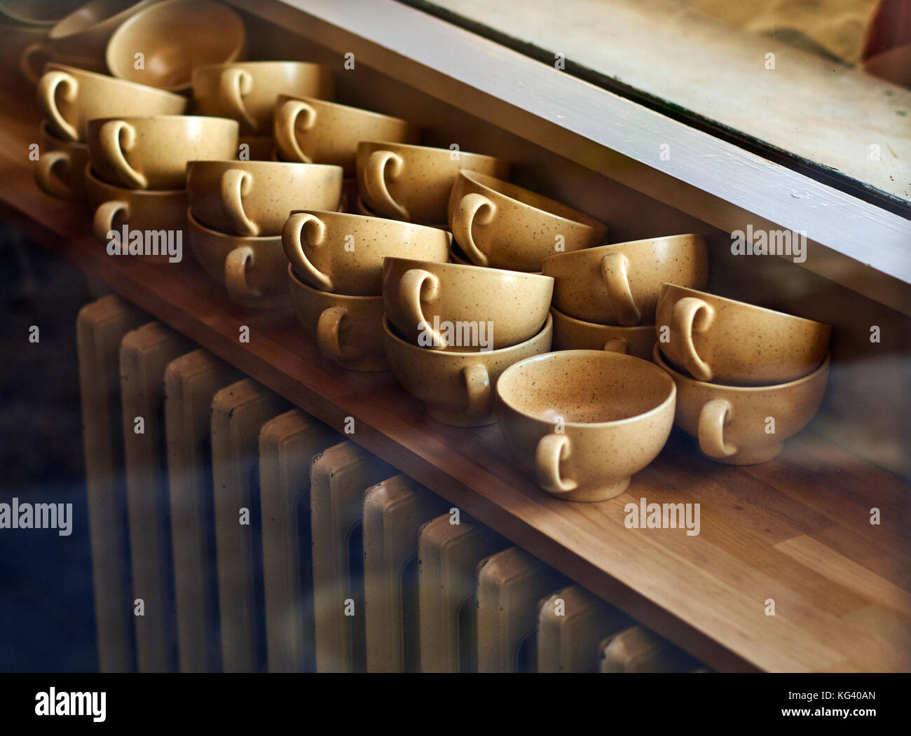 Une pile de tasses à café au-dessus d'un ancien radiateur. Banque D'Images Une pile de tasses à café au-dessus d'un ancien radiateur. Banque D'Images