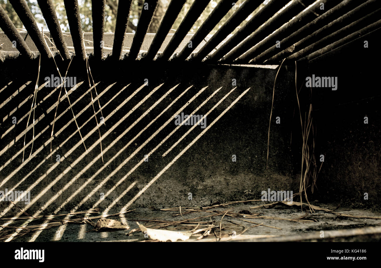 Vieux grill avec ombres joué tout au long de son intérieur Banque D'Images