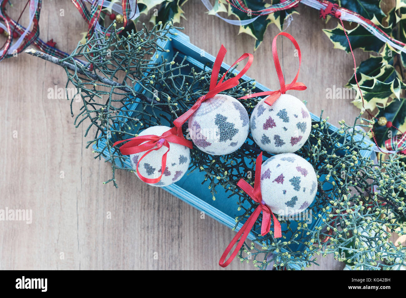 Vue de dessus des boules de noël. photo encadrée de feuilles de gui sur fond de bois. Banque D'Images