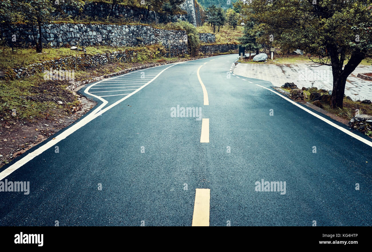 La route d'asphalte mouillé un jour de pluie, harmonisation des couleurs appliquées, travel concept. Banque D'Images