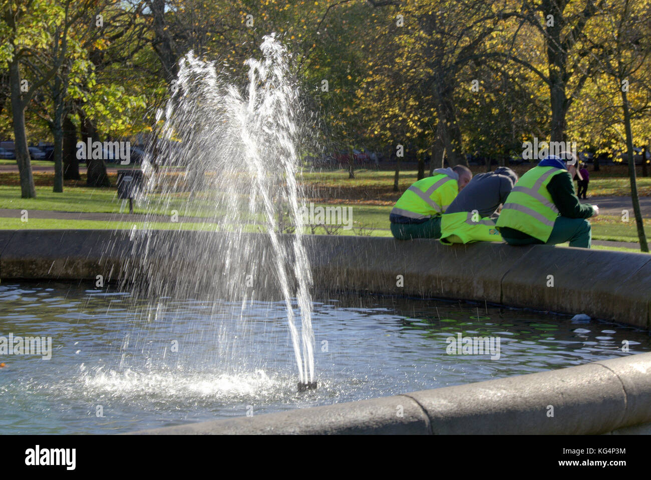 Trois travailleurs parc reposant sur une journée ensoleillée du parc Kelvingrove Stewart Memorial Fountain Banque D'Images