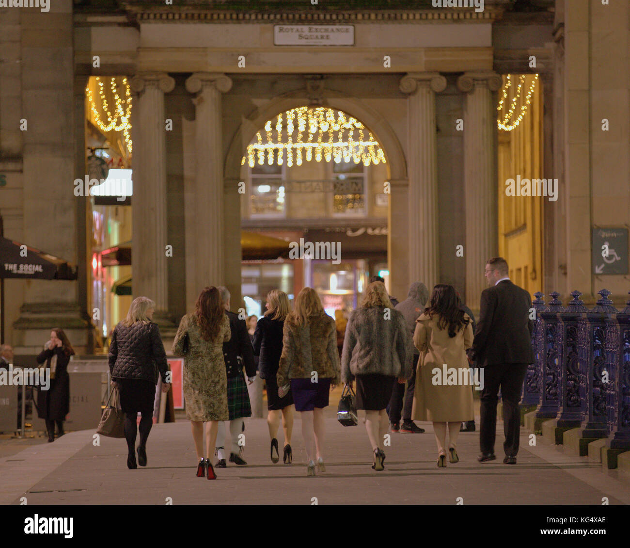 Grande partie des invités du mariage les fêtards sur vendredi samedi nuit en ville habillé Vue de derrière le Royal Exchange Square Banque D'Images