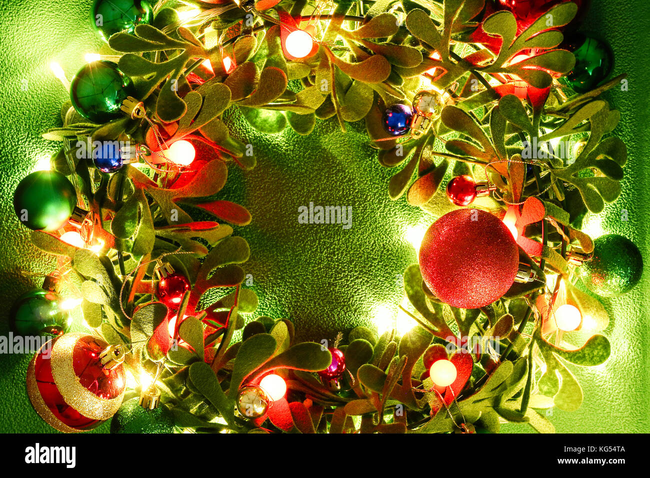 La saison d'accueil concept.couronne de Noël avec les jeux de lumières décoratifs sur fond vert Banque D'Images