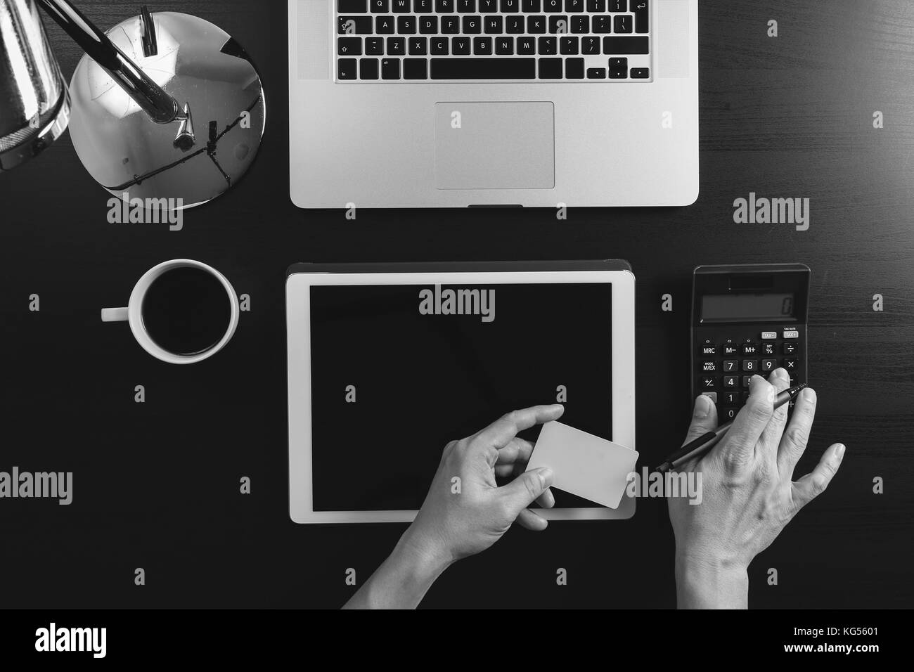 Internet shopping concept.Vue de dessus des mains travaillant avec la calculatrice et l'ordinateur portable et une carte de crédit et l'ordinateur tablette en bois sombre sur fond de table,bla Banque D'Images