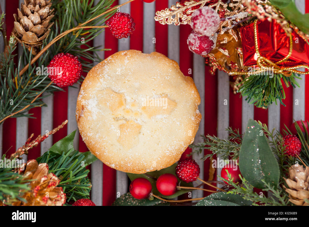 Mince pie fraîchement cuits sur une grille de refroidissement Décorées pour Noël sur fond rouge Banque D'Images