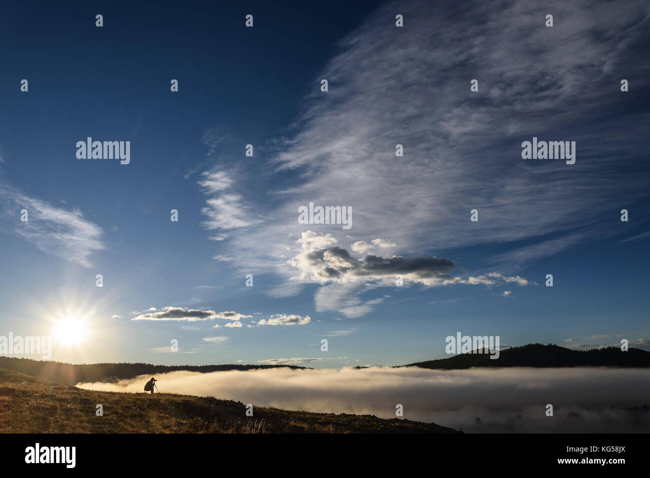 À l'aube d'un photographe prend des photos d'un beau brouillard épais sur le lac du haut de la montagne Banque D'Images