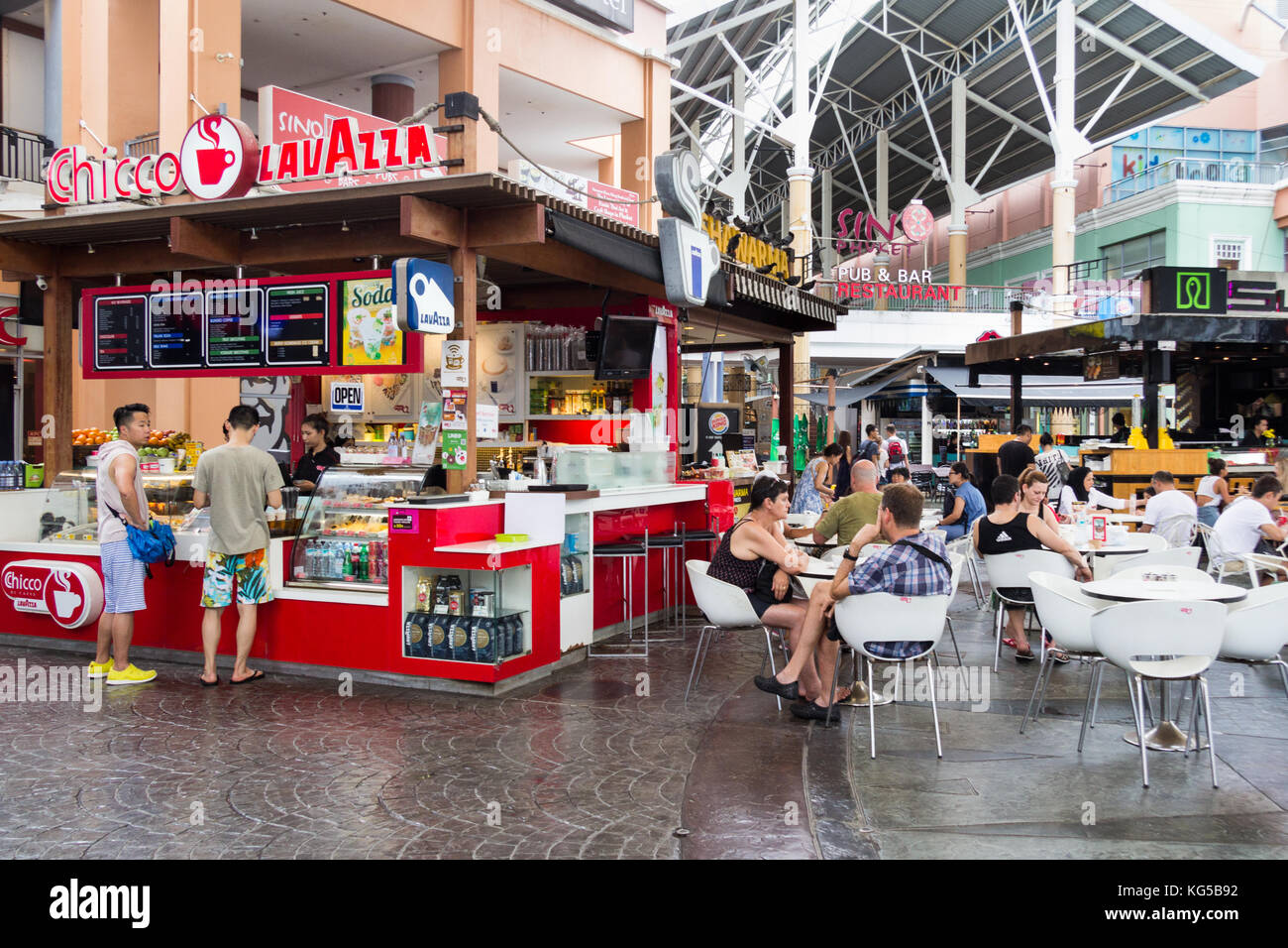 Les gens assis à des tables de boire du café par un café, Jung Ceylon shopping centre, Patong, Phuket, Thailand Banque D'Images
