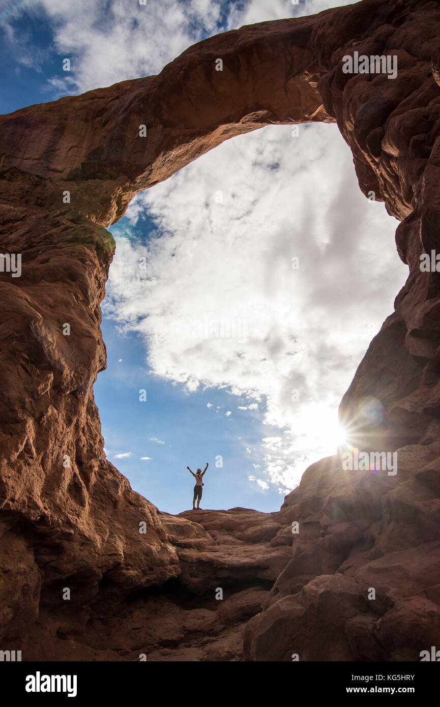 En femme debout dans la tourelle du rétroéclairage arch dans le Arches national park, Utah, USA Banque D'Images