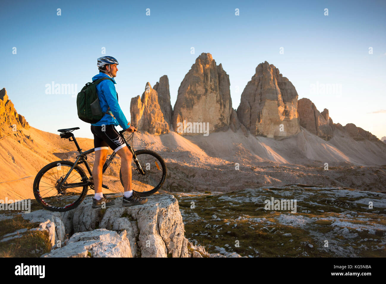 Un motard est à la recherche au coucher du soleil en face de les trois sommets de lavaredo, province de Belluno, Veneto, Italie Banque D'Images