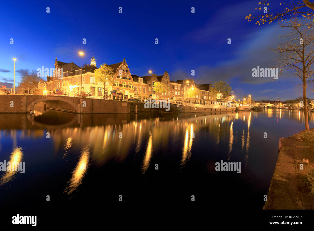 Crépuscule allume le pont de maisons typiques et reflétée dans un canal de la rivière spaarne Haarlem aux Pays-Bas Hollande du Nord Europe Banque D'Images