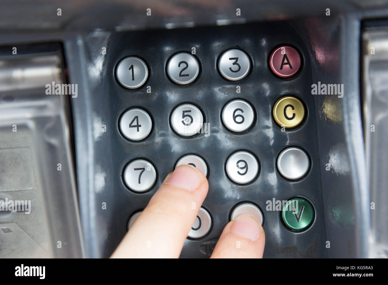 Une main appuyant sur un code PIN pour un virement bancaire avec une carte de crédit. Banque D'Images
