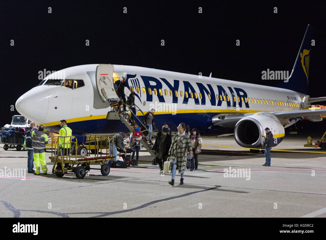 Un Boeing 737-800 de Ryanair stationné à l'aéroport de Bratislava la piste de nuit. Les gens sortent de l'avion. Banque D'Images