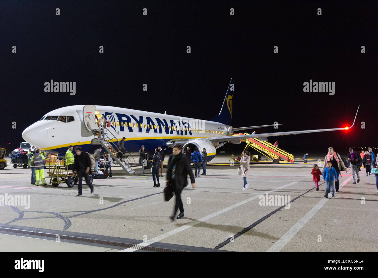 Un Boeing 737-800 de Ryanair stationné à l'aéroport de Bratislava la piste de nuit. Les gens sortent de l'avion. Banque D'Images