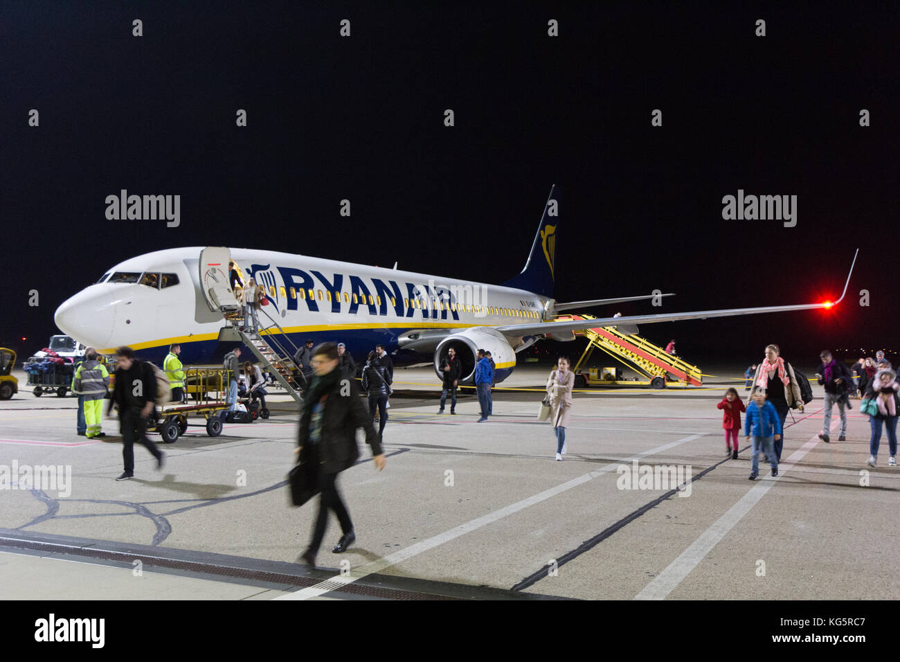 Un Boeing 737-800 de Ryanair stationné à l'aéroport de Bratislava la piste de nuit. Les gens sortent de l'avion. Banque D'Images